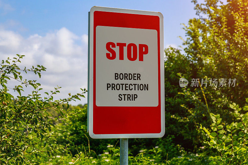 英文题词或文字为STOP BORDER PROTECTION STRIP。州边界的警示牌。背景